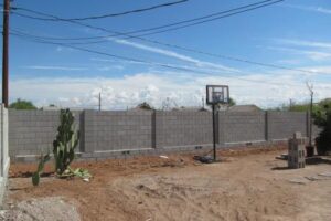 A basketball hoop in the middle of an empty lot.