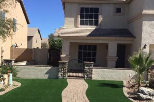 A house with a gate and walkway in the front yard.