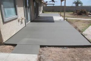 A concrete slab is being installed on the patio.