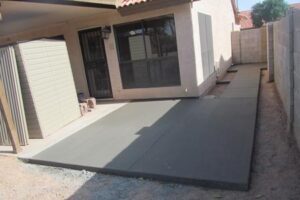 A patio with a black tarp covering the ground.