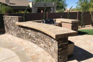 A stone bench with a grill in the middle of it.