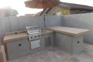 A bbq grill and sink in an outdoor kitchen.