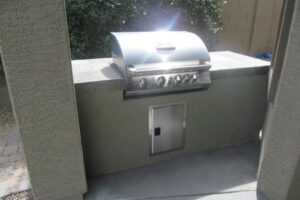 A grill sitting on top of a concrete counter.