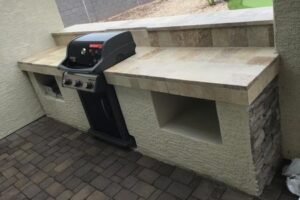 A grill sitting on top of a brick patio.