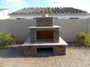 A brick fireplace sitting in the middle of a patio.