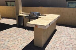 A bbq grill sitting on top of a stone counter.