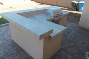 A grill sitting on top of a concrete block.