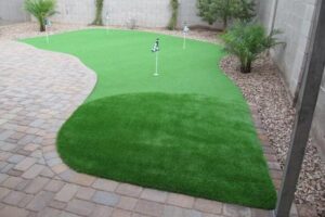 A backyard putting green with a golf course flag.