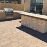 A bbq grill and counter in an outdoor patio.