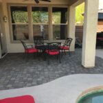 A patio with a table and chairs in the middle of it