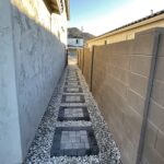 A walkway with stepping stones in between two buildings.