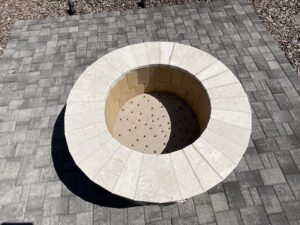 A circular fire pit with a round design on the side.