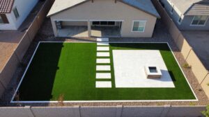 A backyard with a fire pit and grass.