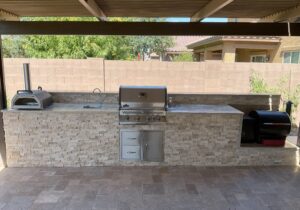 A grill and sink in an outdoor kitchen.