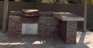 A stone wall and outdoor kitchen with an oven.