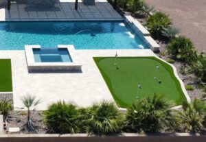 A pool with a green area and a golf course.