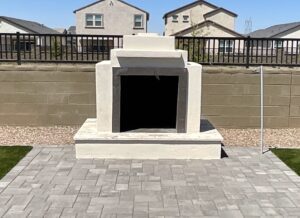 A stone fireplace with a black door on the side.