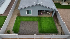 A house with grass and concrete in the yard.