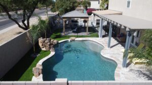 A pool with a gazebo and a rock garden.