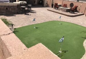 A backyard with a putting green and several flags.