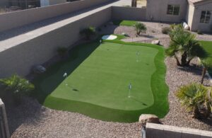 A backyard with a putting green and a golf course.