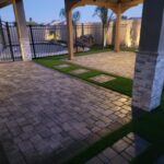 A patio with pavers and artificial grass