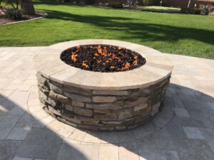 A fire pit sitting on top of a brick patio.