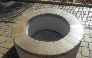 A fire pit with circular design in the middle of it.