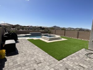 A backyard with a pool and a large lawn.