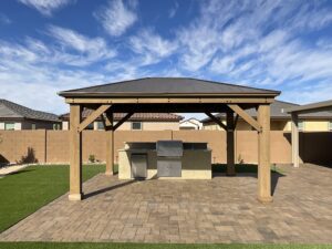 A large wooden structure with a roof and a stone patio.