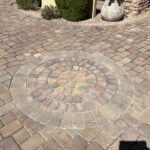 A brick patio with a circular pattern in the center.