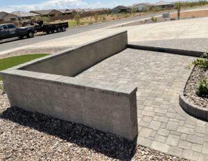 A concrete bench sitting in the middle of a driveway.