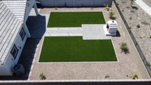 A view of a backyard with a grass area.